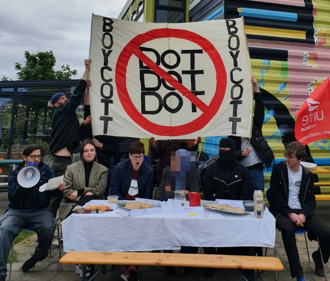 Dot Dot Dot protesters with banner reading 'Boycott Dot Dot Dot"