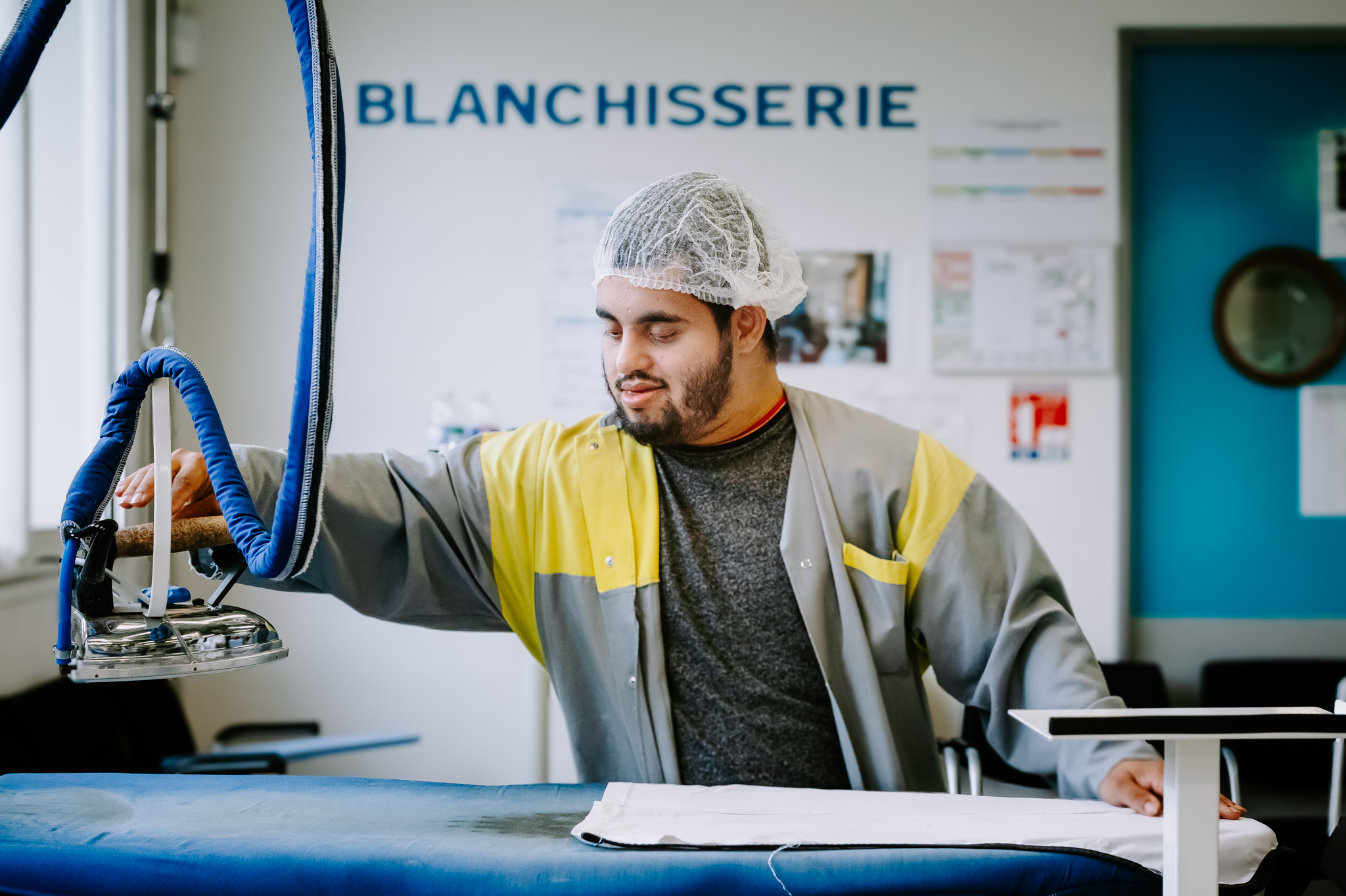 Groupe Laverie Solidaire France Olympics disability and inclusion Portrait of a man ironing in front of "Blanchisserie" sign