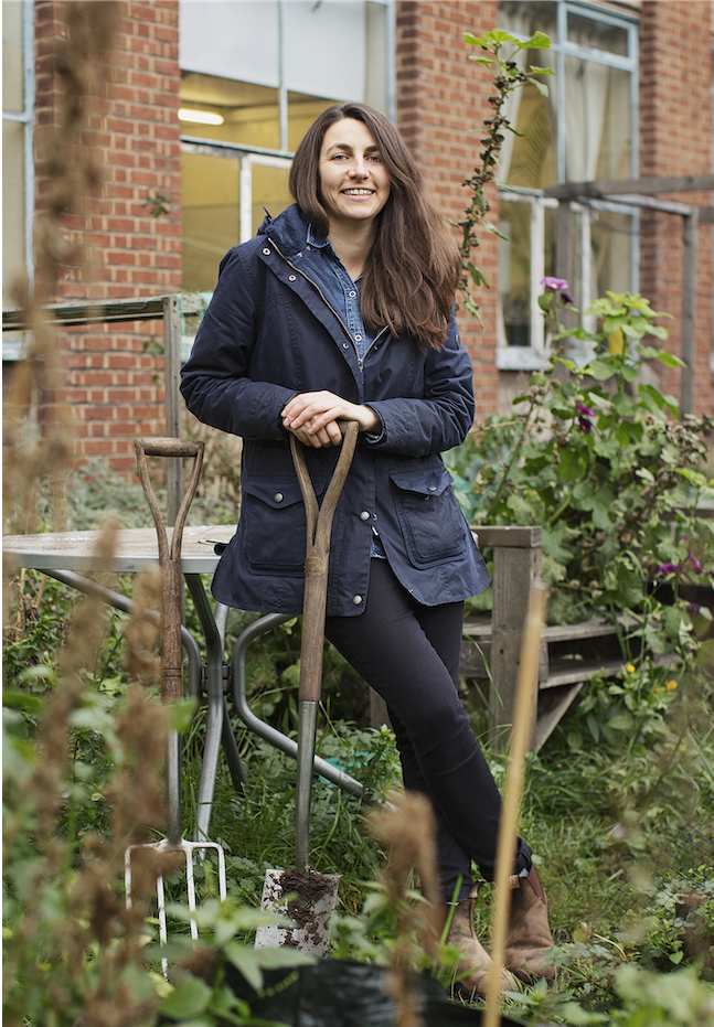 Social entrepeneur Nat Mady centre screen in a garden with a shovel in hand