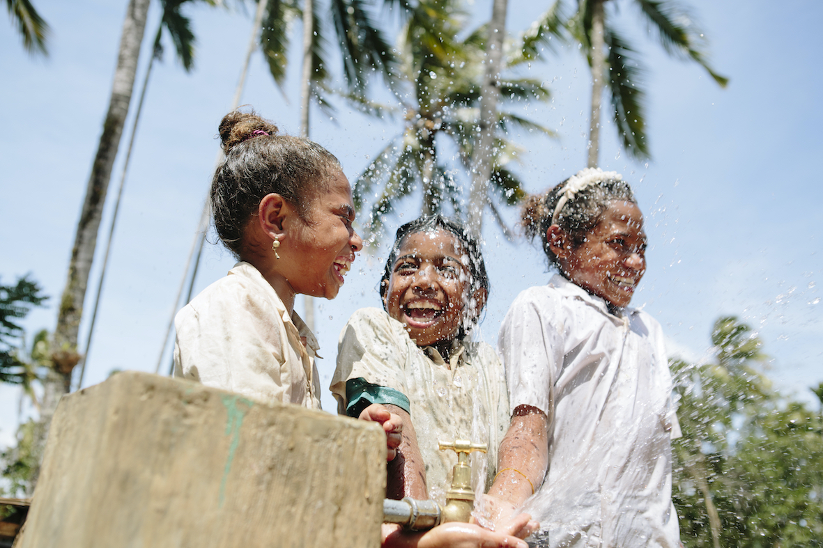 Children at tap with WaterAid Belu