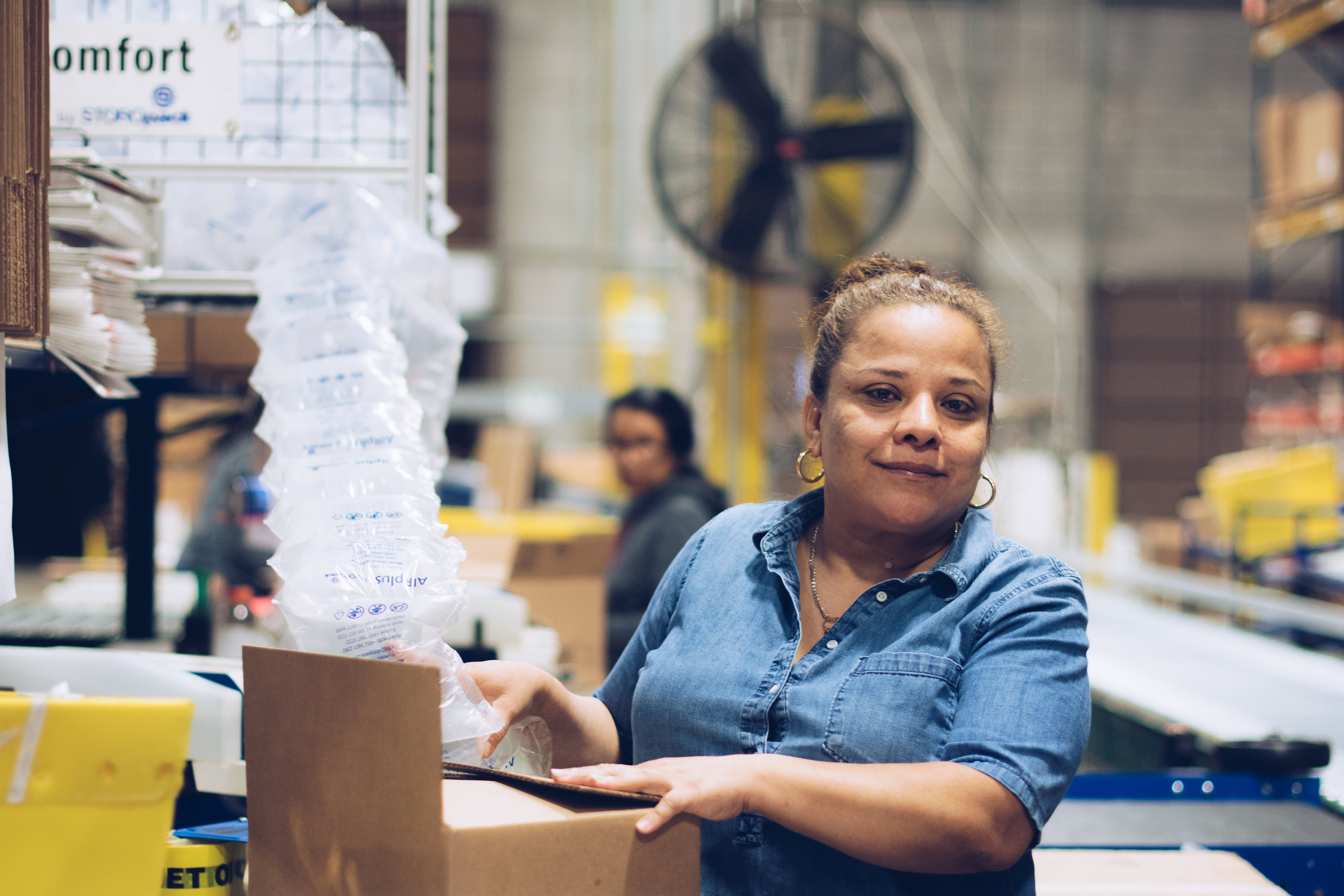 Woman working in a warehouse supported by First Step Staffing. The non-profit helps people facing barriers to employment find jobs