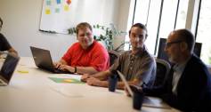 Three auticon consultants sitting at desk