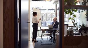 Man and woman discussing in office by Pexels