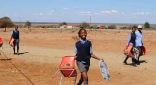 School girl takes a chair and tutudesk to school