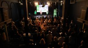 Singers from social enterprise Shared Harmony on stage with audience standing up