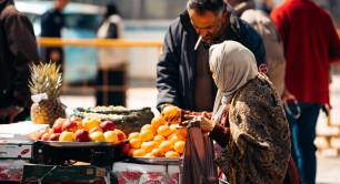 A woman buys oranges in a market in Amman, Jordan