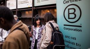 people next to B Corp logo sign