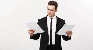 Man in suit comparing two reports