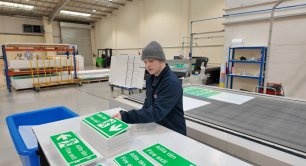 Nuneaton Signs employee Alex using printing machine