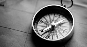 Black and white photo of a compass on a map