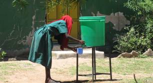 A woman draws water from a clean drinking water tank