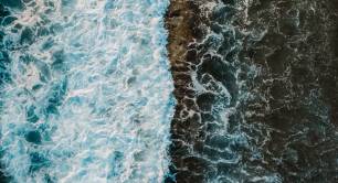 top view of wave breaking on rocks