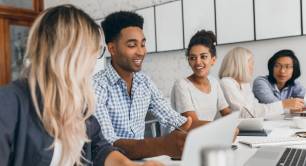 Group of diverse young people chatting in office